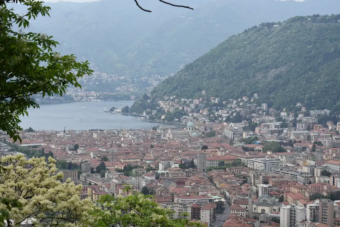 View from the woods of the Spina Verde park over the rooftops of Como to the lake
