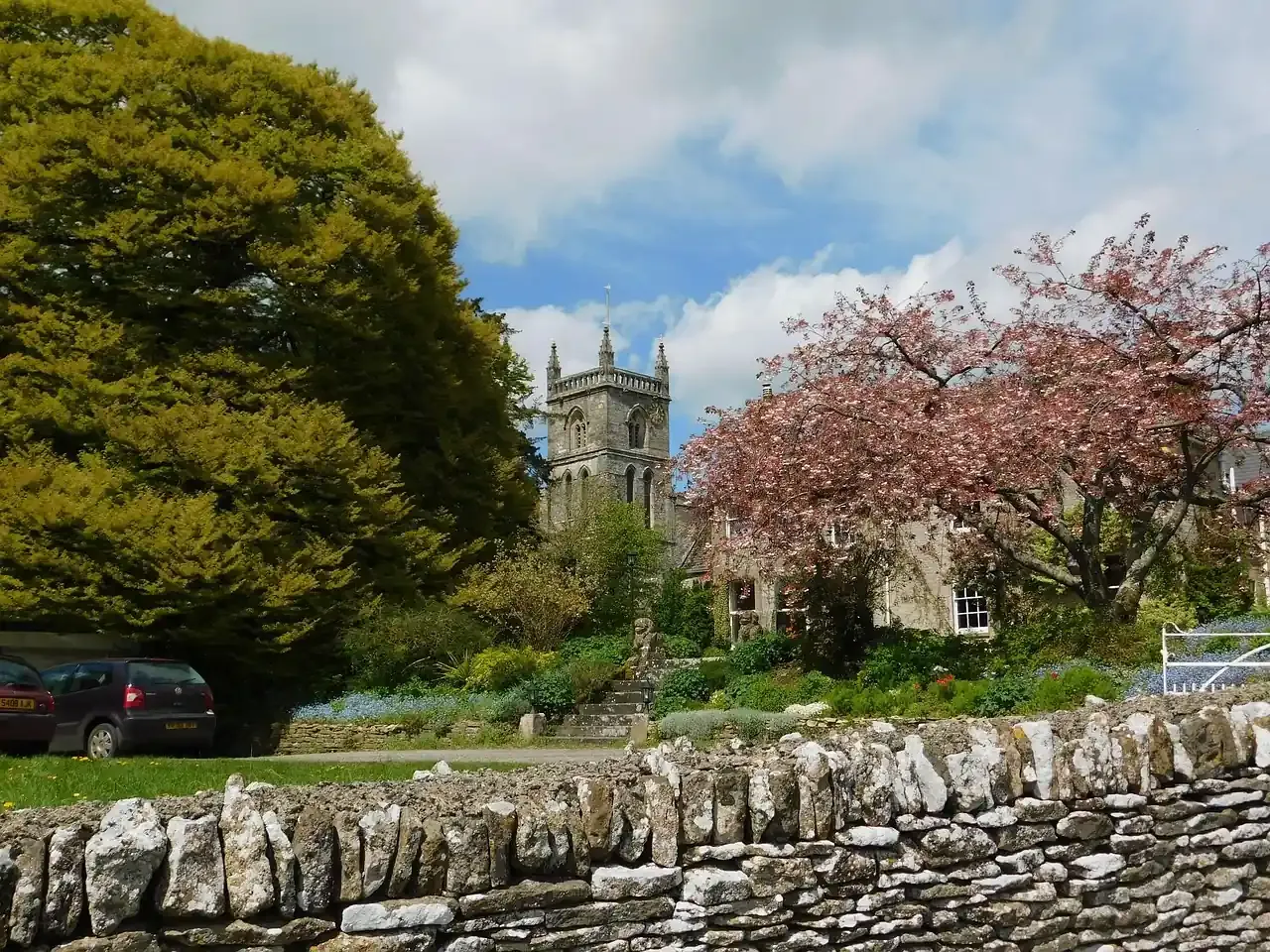 A church and stone cottages in a Cotswolds village