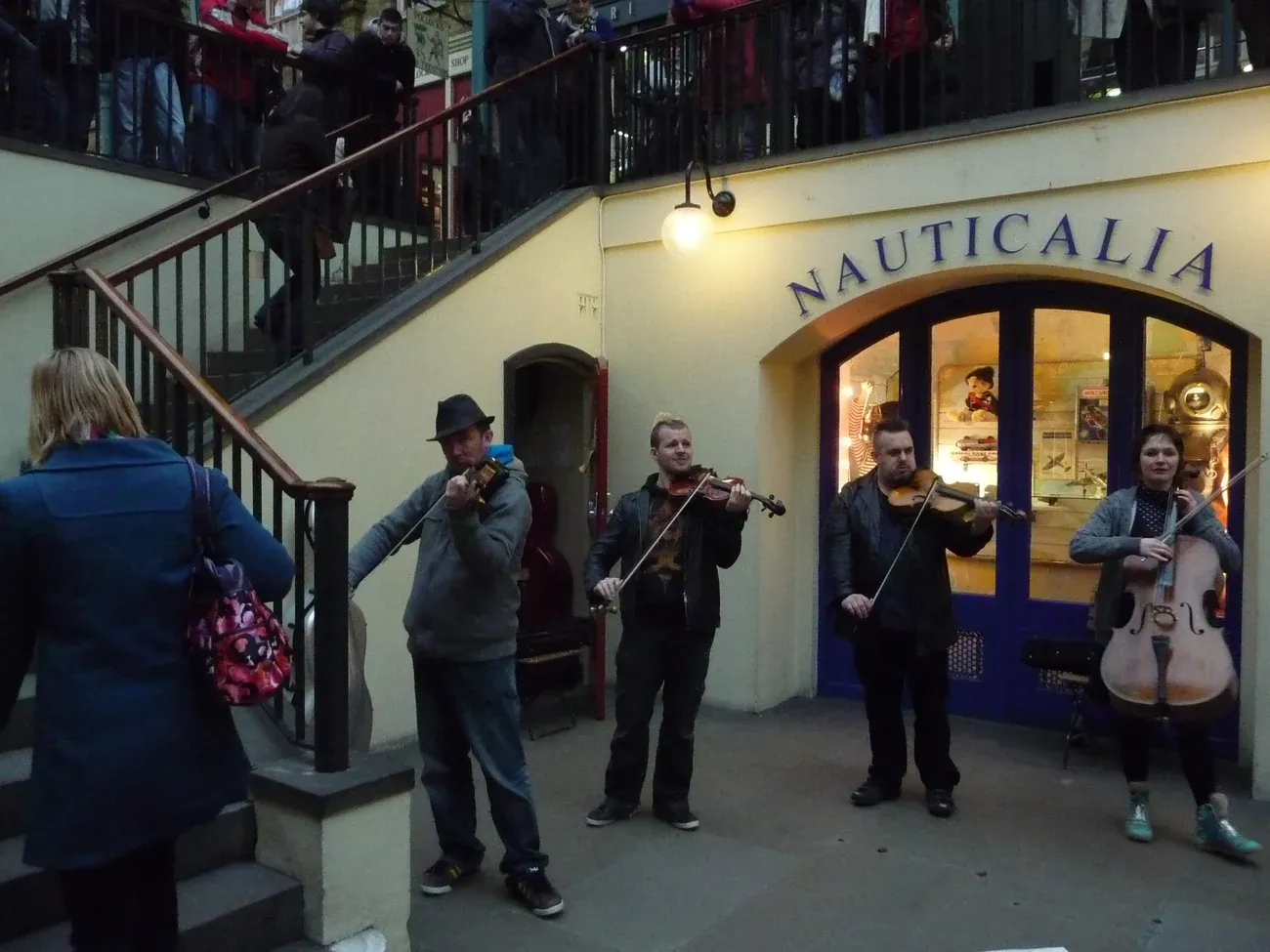 String musicians performing to a crowd in the lower courtyard of the Covent Garden Market Building, London