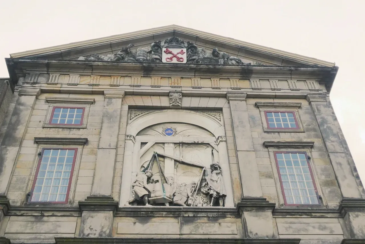 The carved pediment of De Waag, the 17th century weigh house in Leiden, bearing the city's crossed keys, Netherlands