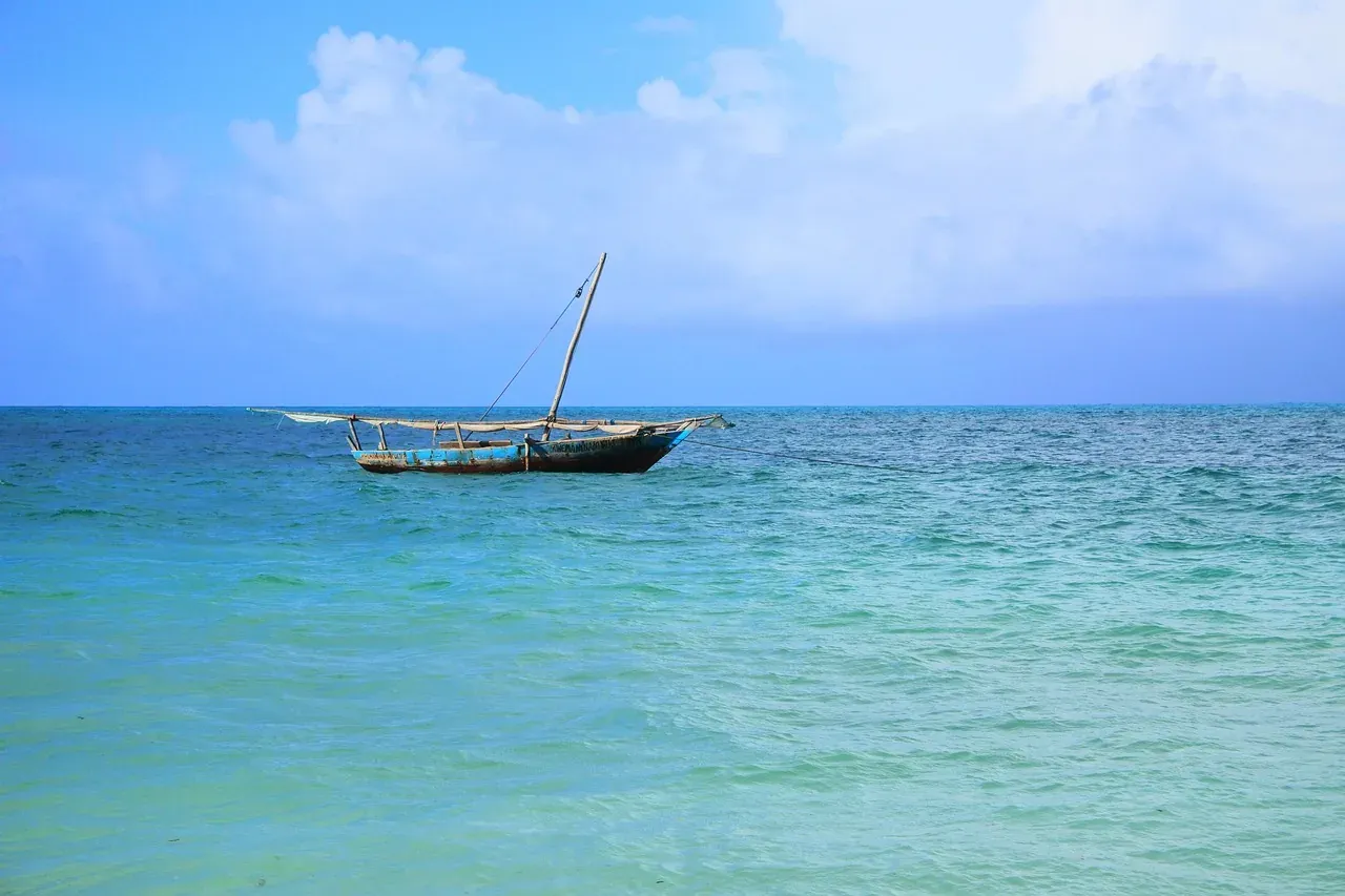 A dhow sailing on turquoise water off Zanzibar, Tanzania