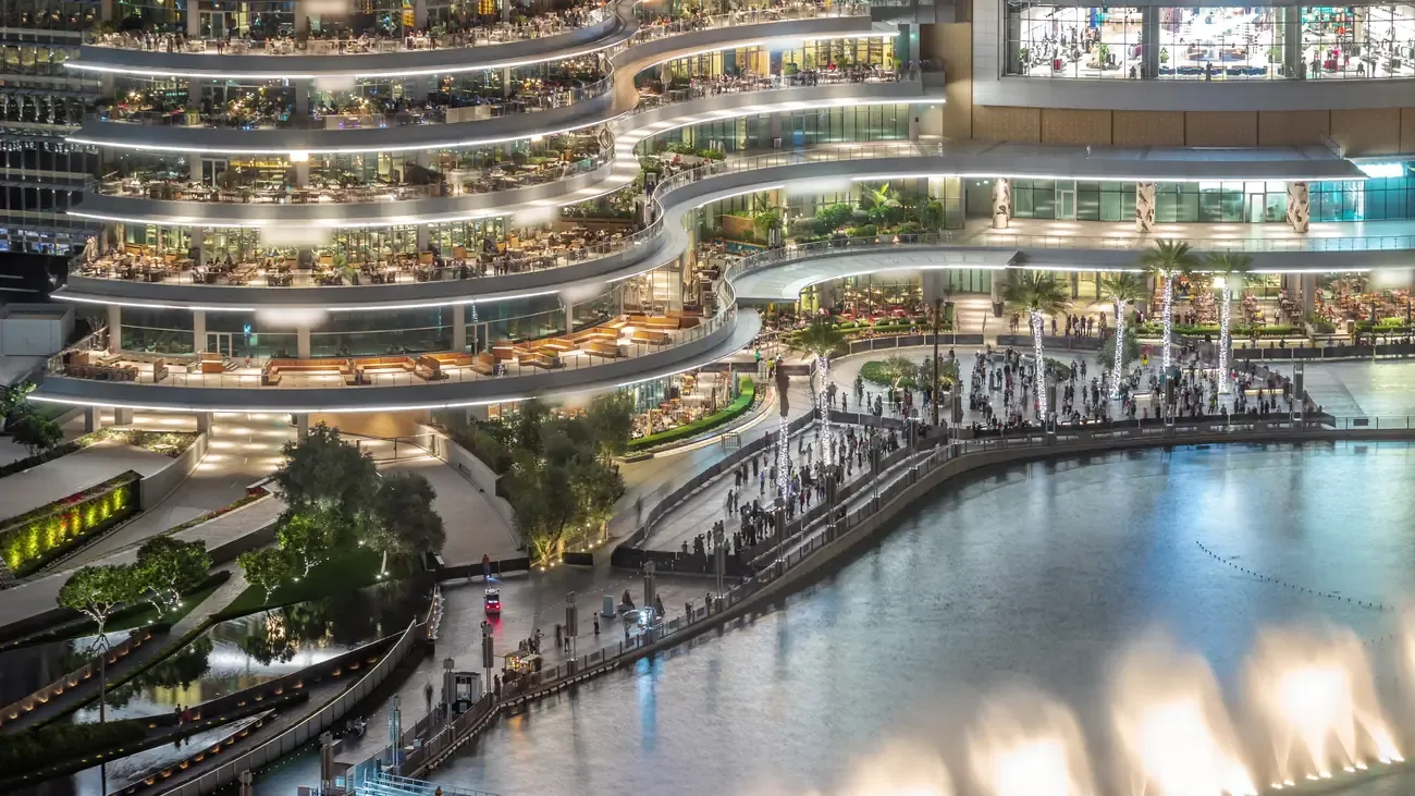 The restaurant balconies of the Dubai Mall over the fountain lake at dusk
