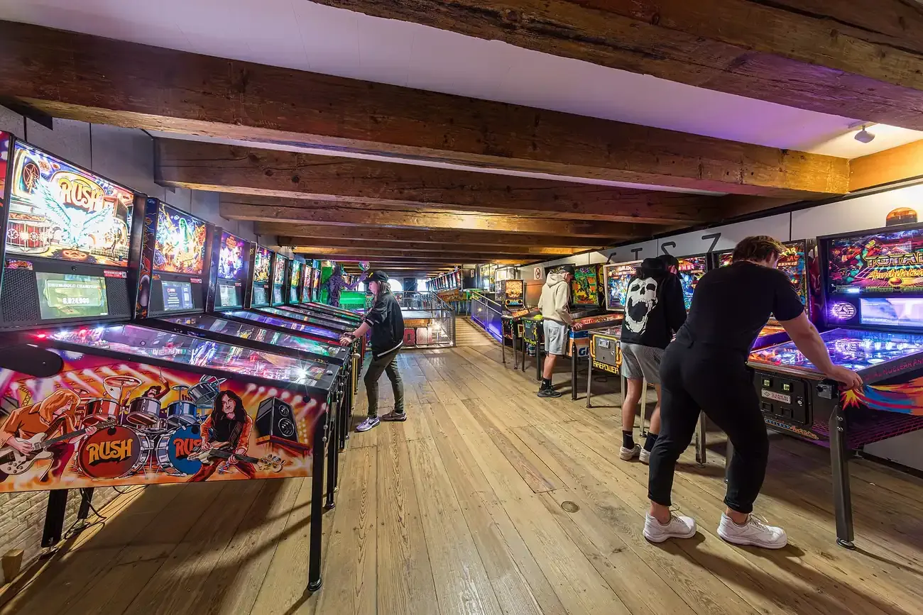 Rows of lit pinball machines in the hall of the Dutch Pinball Museum in Rotterdam