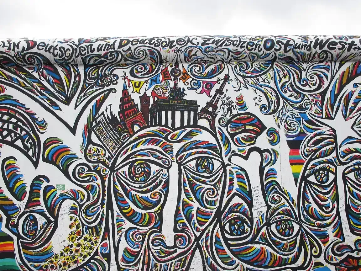 A mural of interlocking faces on the East Side Gallery in Berlin
