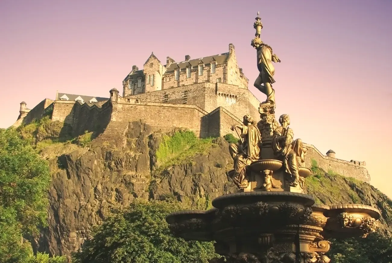 Edinburgh Castle on Castle Rock above the Ross Fountain at sunset