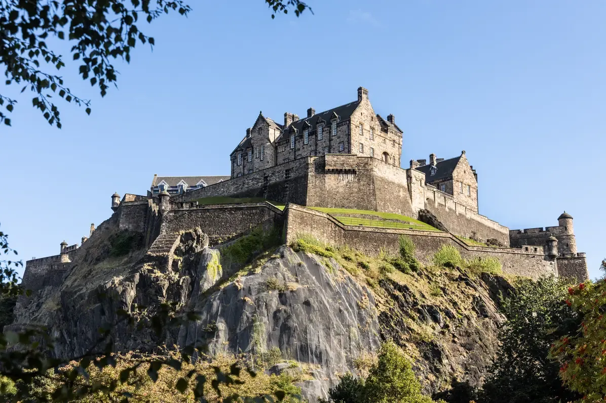 Edinburgh Castle standing on the volcanic crag of Castle Rock above the trees below