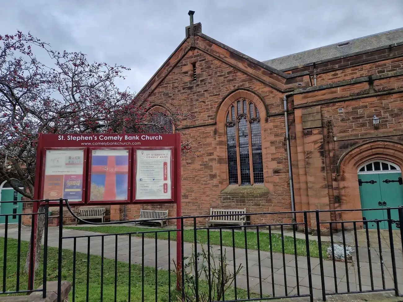 Red sandstone St Stephen's Comely Bank Church and its noticeboard in Edinburgh