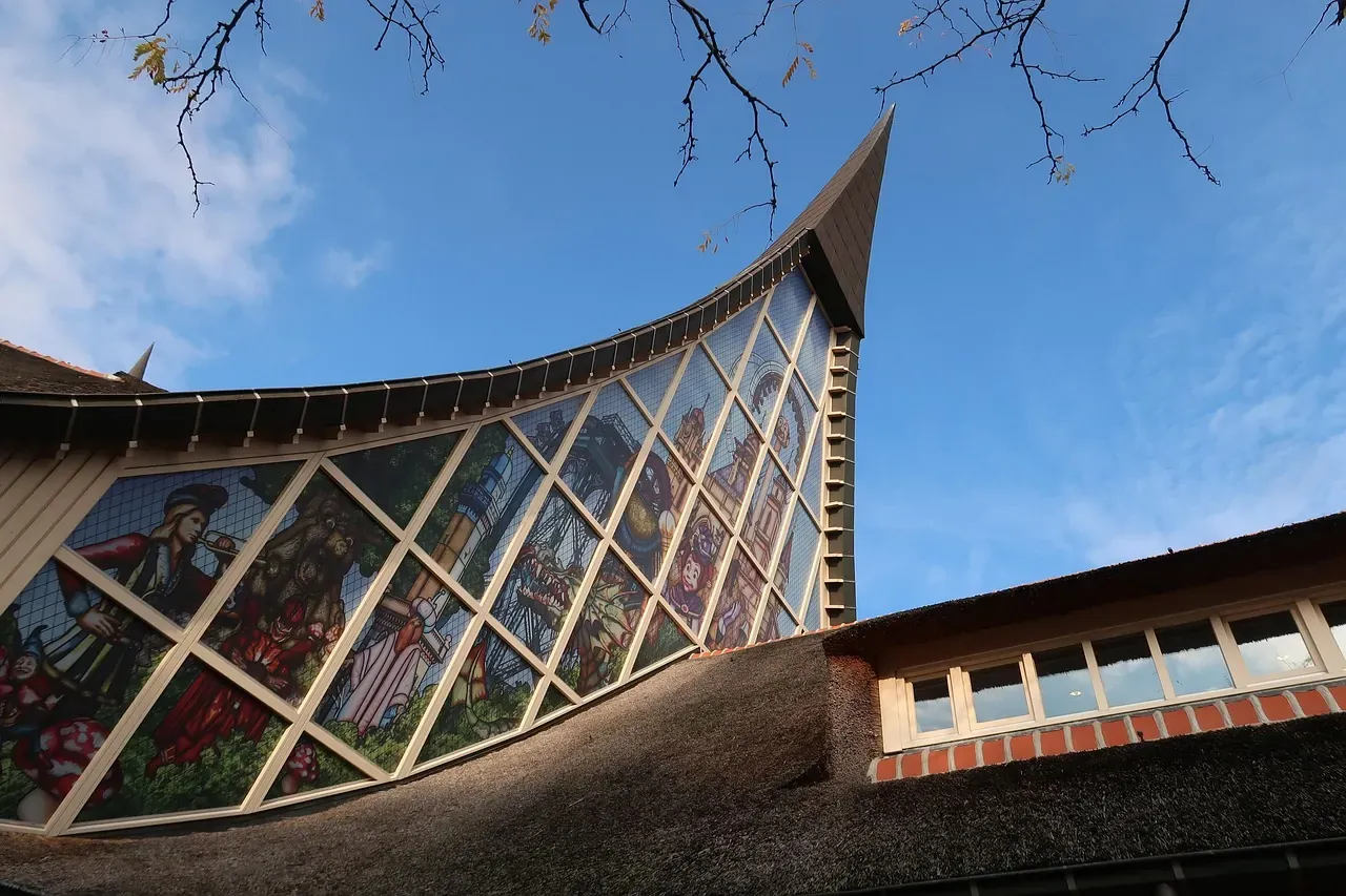 The curved roofline and stained glass wall of a themed pavilion at Efteling