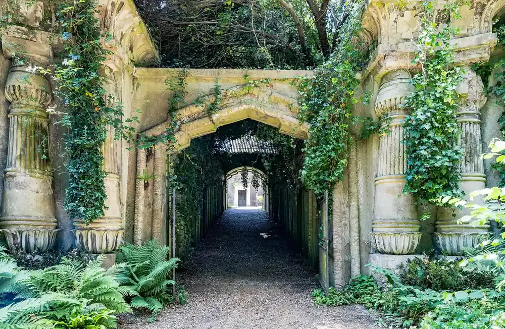 The entrance to the Egyptian Avenue between ivy-covered columns at Highgate Cemetery in London