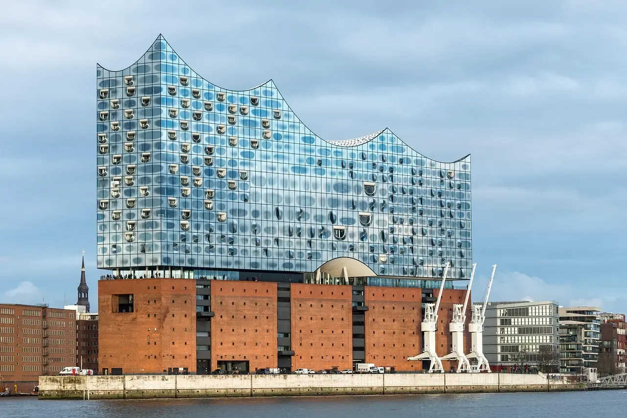 The Elbphilharmonie seen from the water beside the harbour cranes of HafenCity in Hamburg