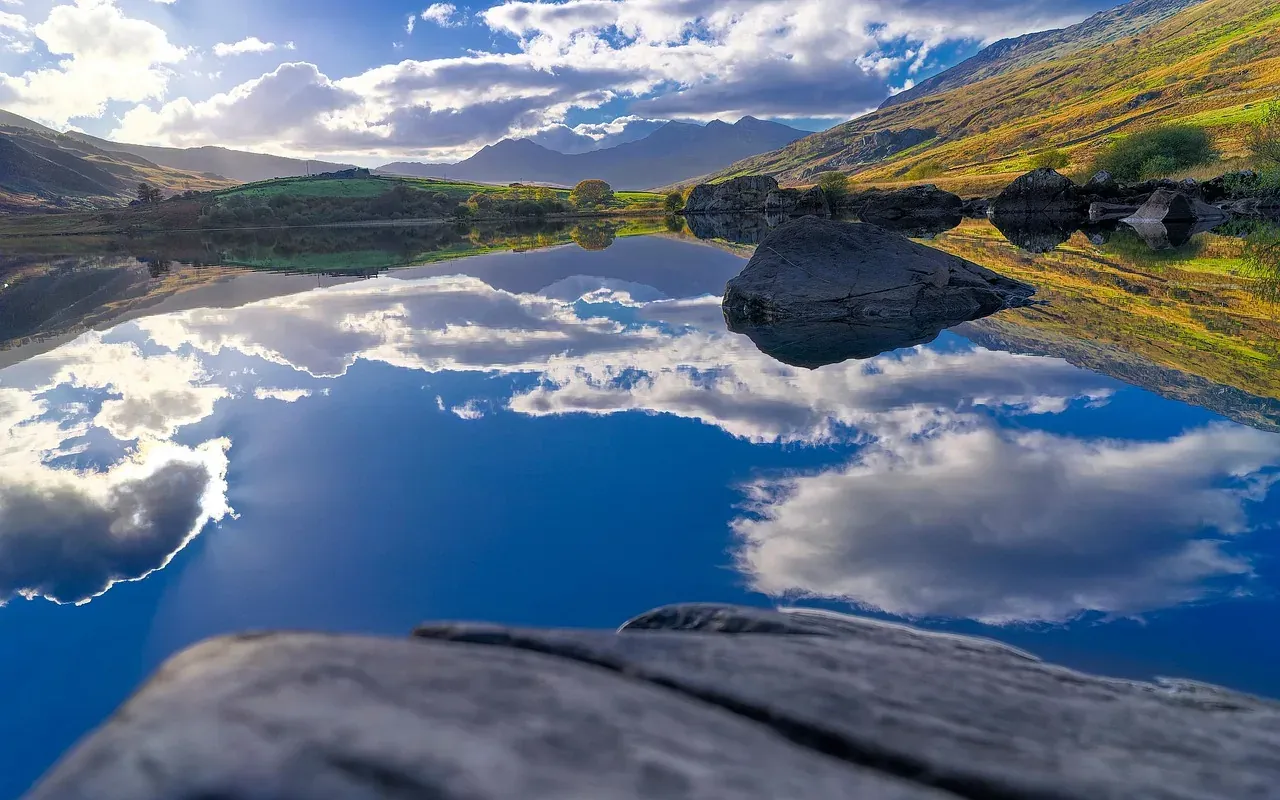 Still water reflecting the valley walls of Eryri in Wales