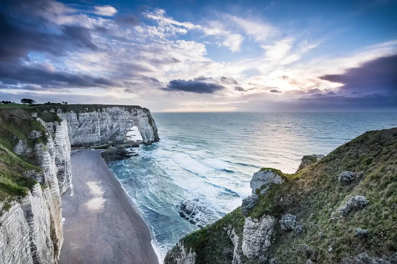 The chalk cliffs and pebble beach of Etretat in Normandy at dusk
