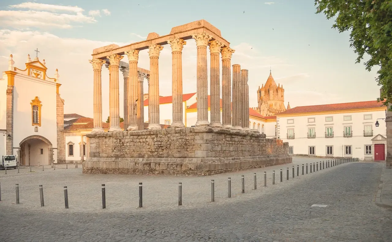 The Corinthian columns of the Roman temple of Evora with the cathedral tower behind