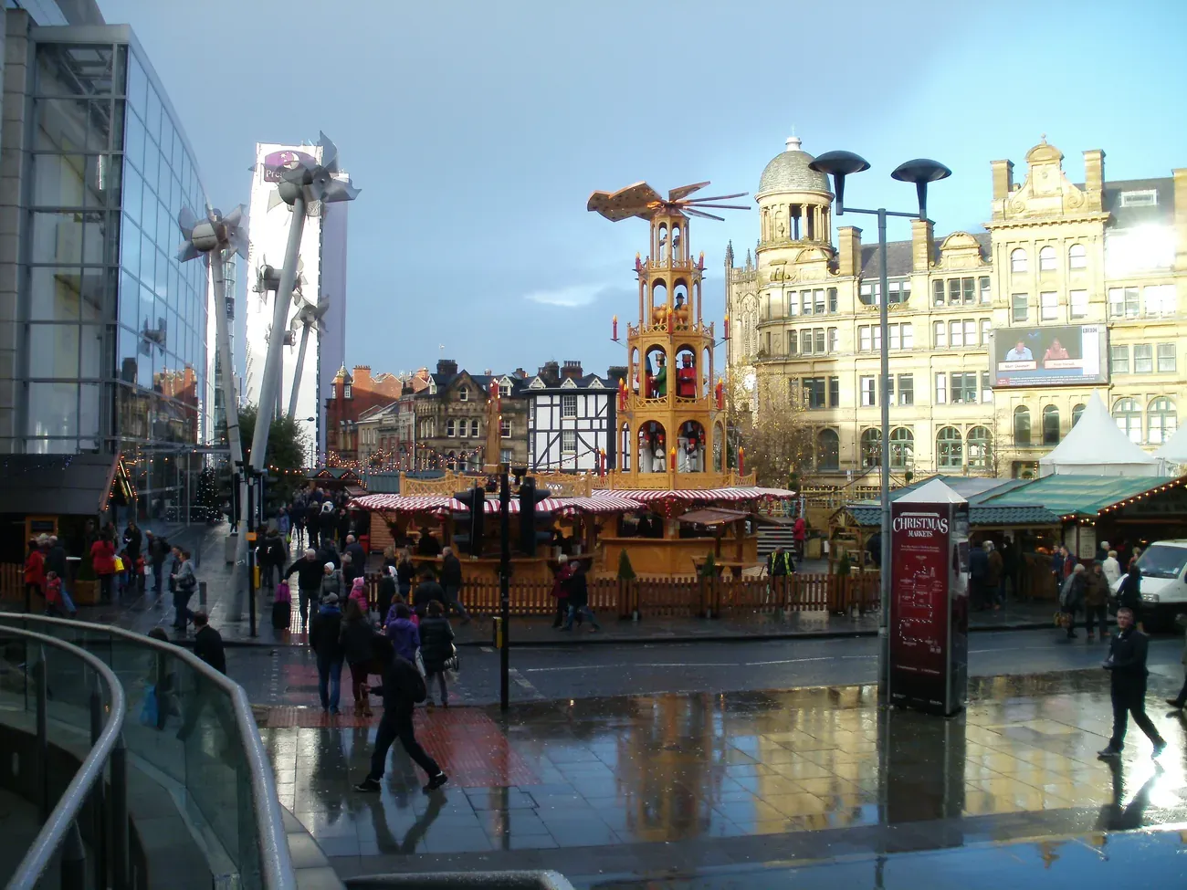 Christmas market chalets in Exchange Square with the Corn Exchange behind, Manchester