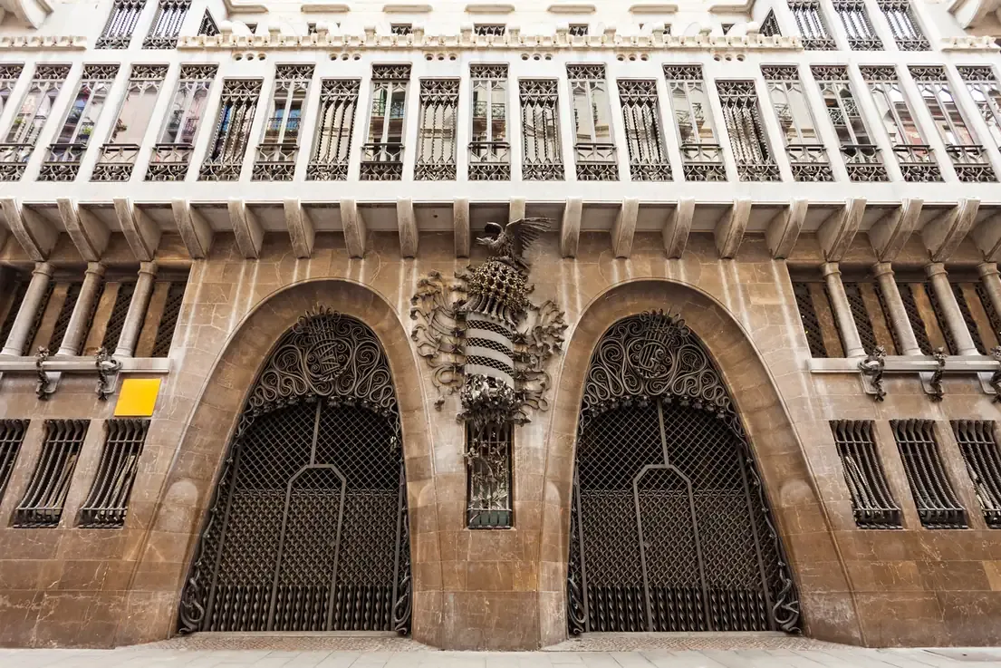 The street facade of Palau Guell with its parabolic entrance arches in Barcelona