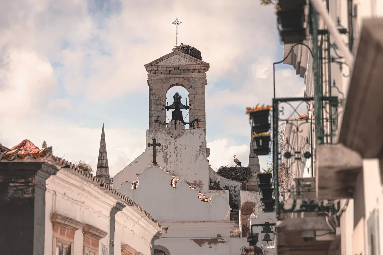 Historic bell tower with a stork nest above the whitewashed old town of Faro, Portugal