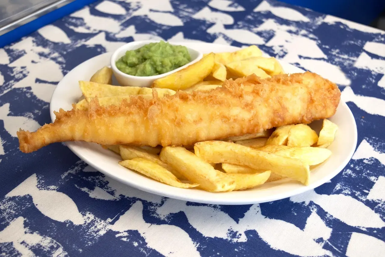 Battered fish with chips and mushy peas on a plate