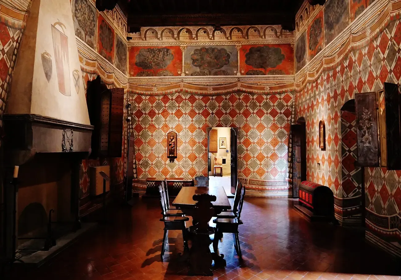 The painted Sala dei Pappagalli with its parrot-patterned walls and fireplace in Palazzo Davanzati, Florence