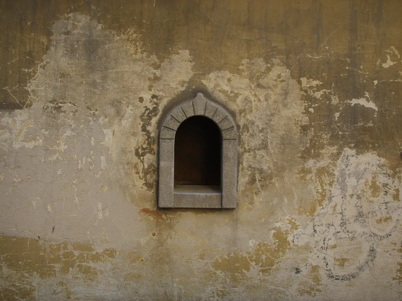 A buchetta del vino, a small arched wine window in a wall in Via Santo Spirito in Florence