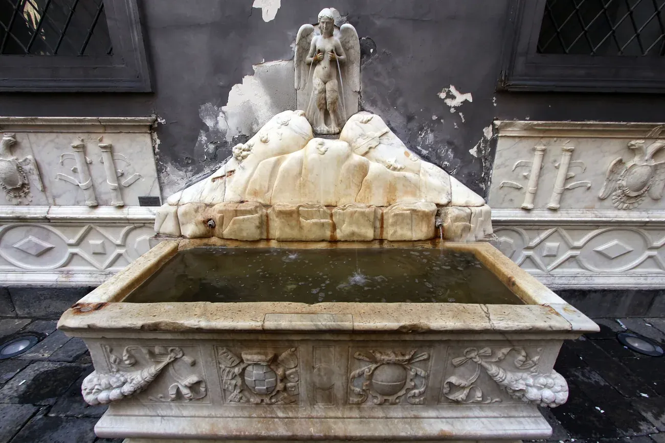 The Renaissance Spinacorona fountain with its marble basin and winged siren on top, Naples