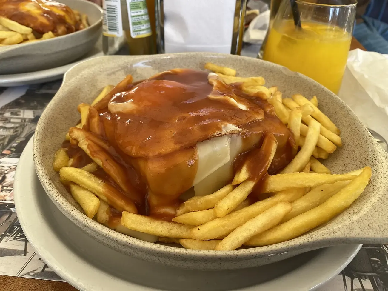 A francesinha under beer sauce with chips, Porto