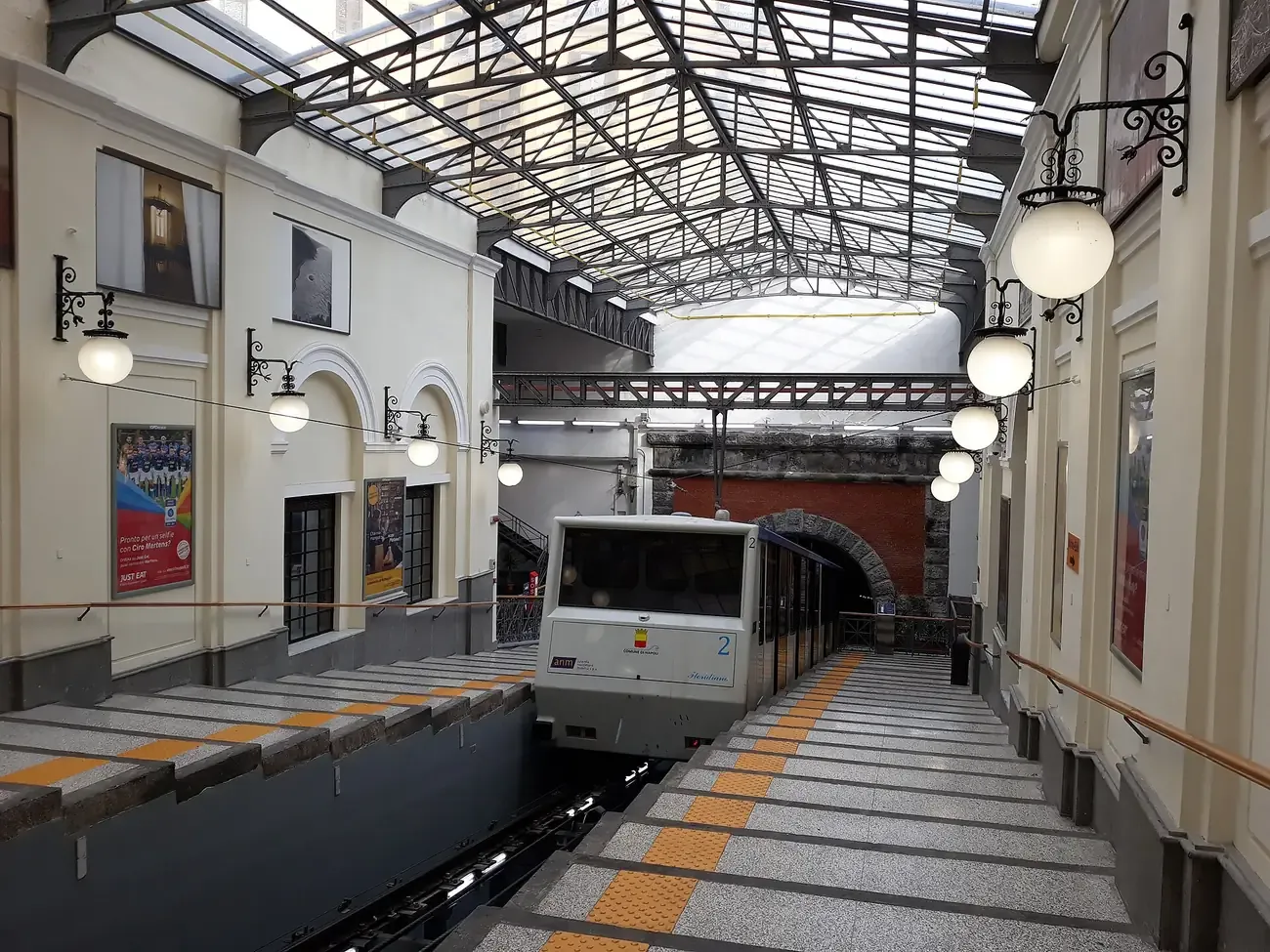 A Funicolare Centrale car arriving at the glass-roofed Piazza Fuga station in the Vomero district of Naples