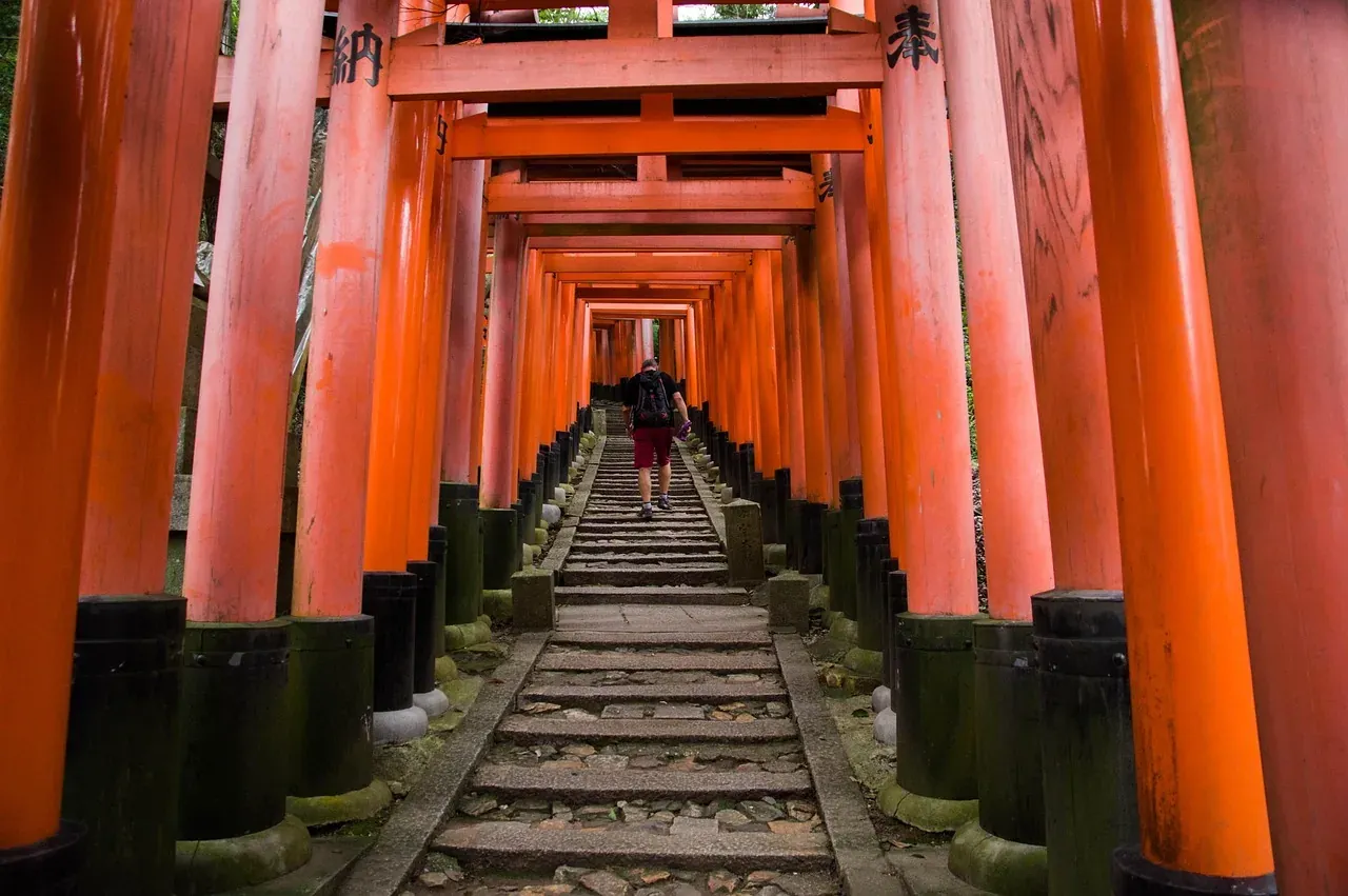 A walker on the torii-lined trail up Mount Inari in Kyoto