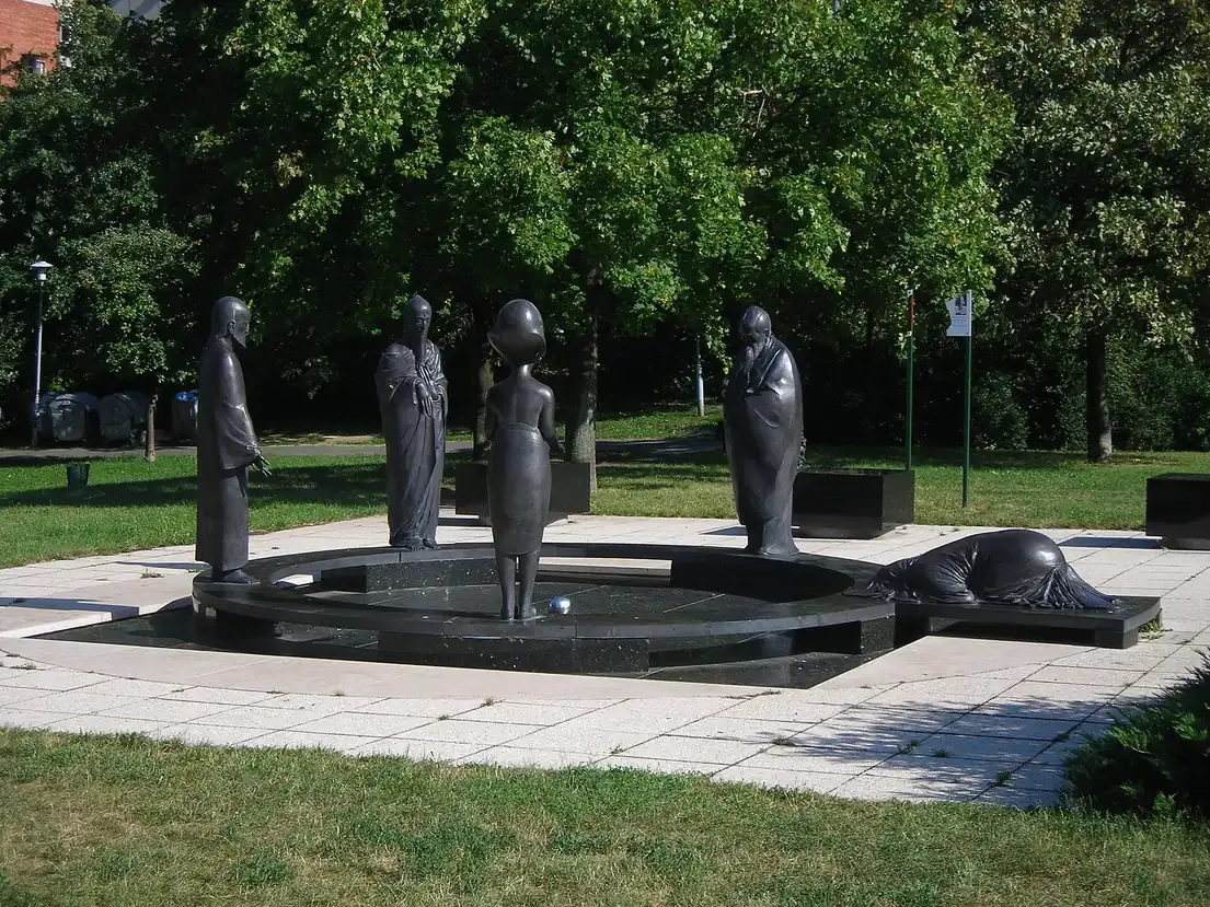 Bronze figures of religious founders standing in a circle around a sphere in the Garden of Philosophy on Gellert Hill in Budapest