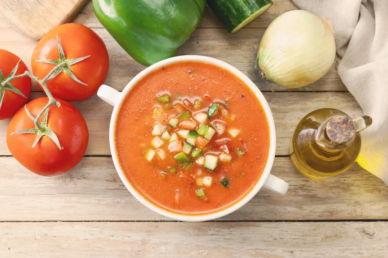 A bowl of Andalusian gazpacho topped with diced cucumber, pepper and tomato