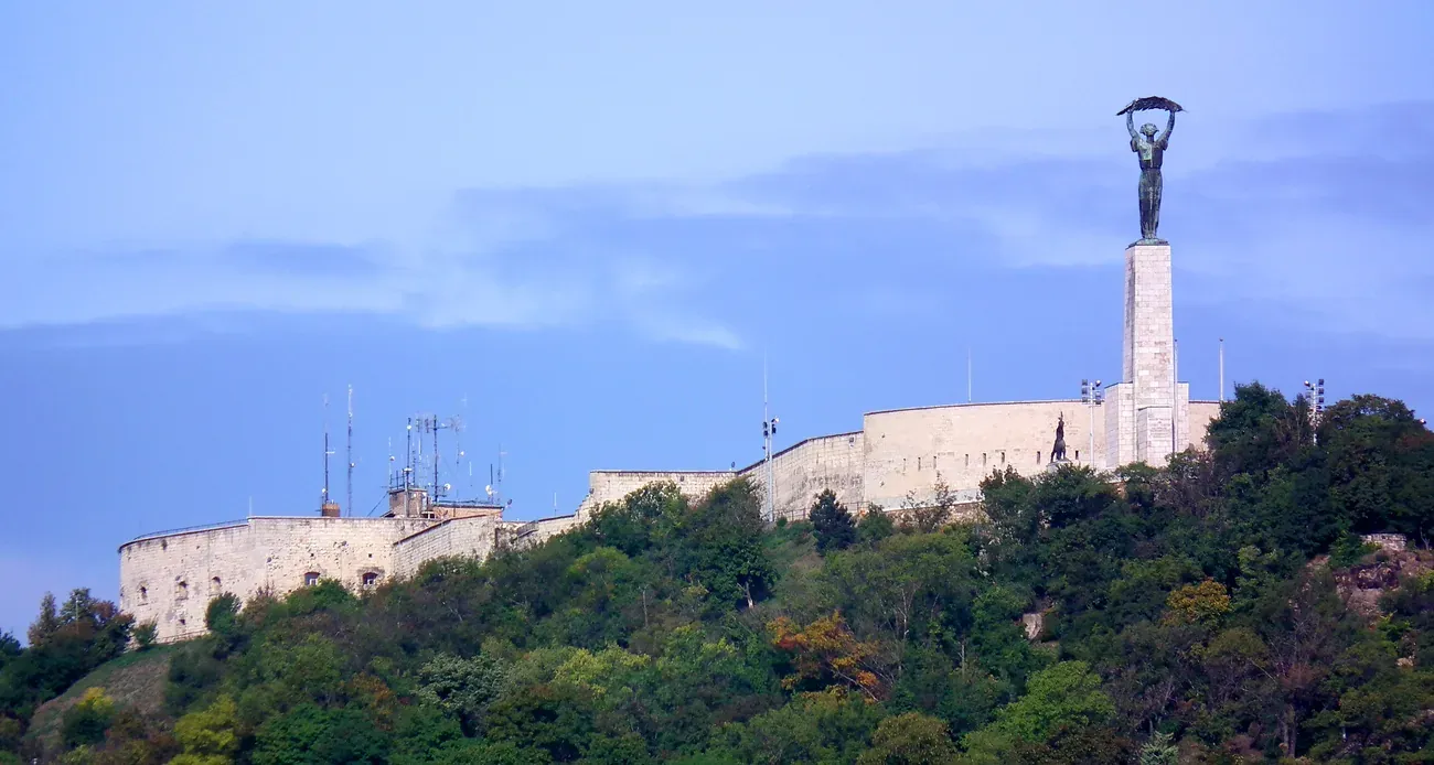 The wooded Gellért Hill in Budapest crowned by the Citadella walls and the Liberty Statue
