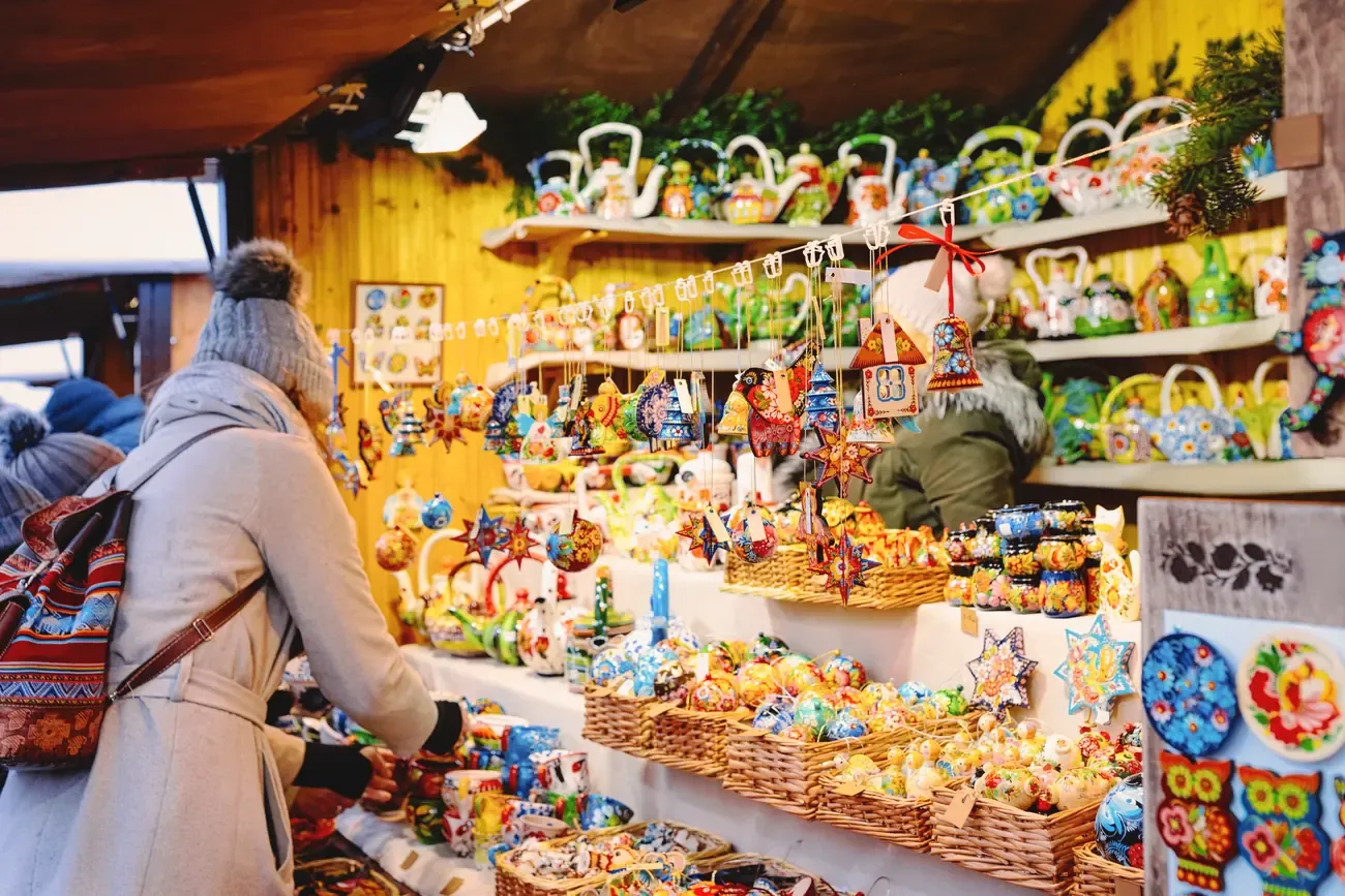 Visitor at a stall selling wooden Christmas decorations at the Gendarmenmarkt Christmas market in Berlin