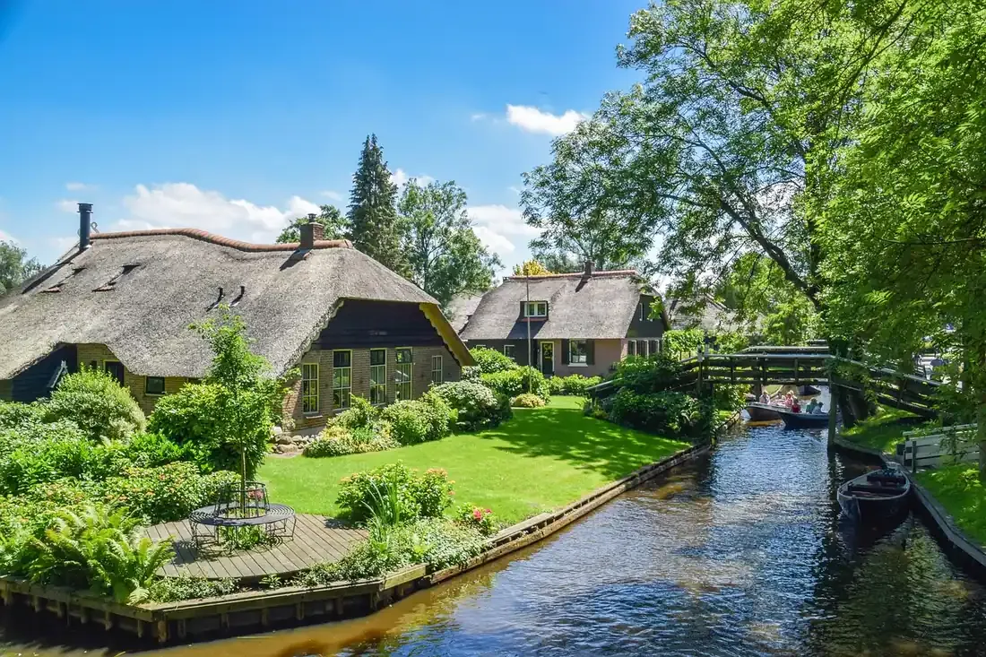 Thatched houses and a wooden footbridge over the canal at Giethoorn