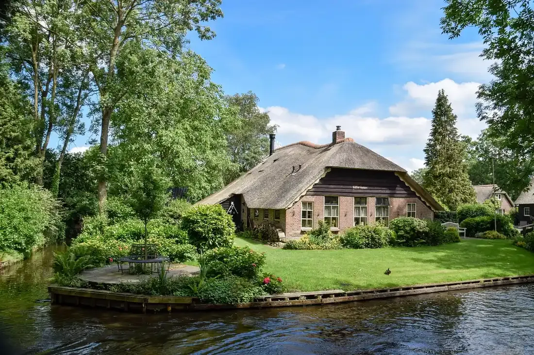 A thatched farmhouse and garden beside the main canal at Giethoorn in Overijssel