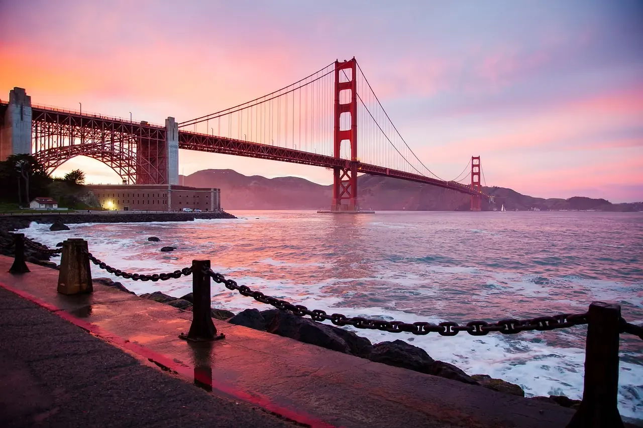The Golden Gate Bridge seen from the shore at sunrise in San Francisco