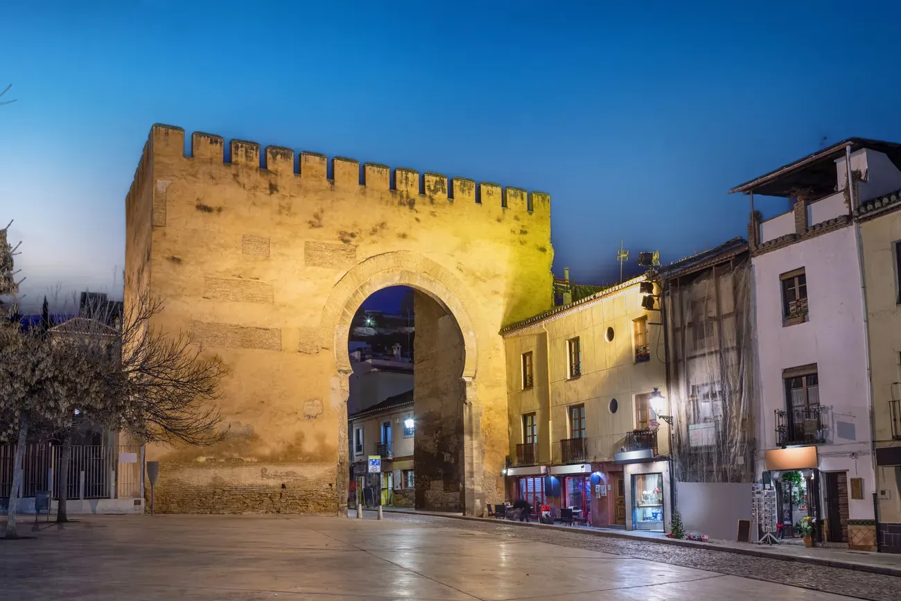 The historic Puerta de Elvira gate at dusk in Granada