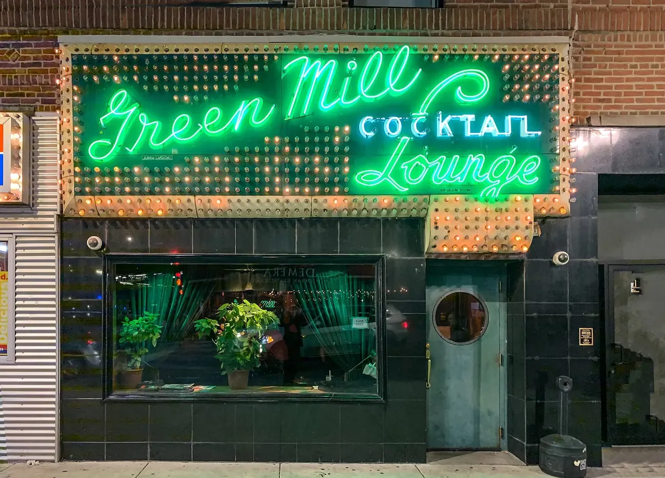The illuminated vintage neon sign of the Green Mill jazz club in Uptown Chicago