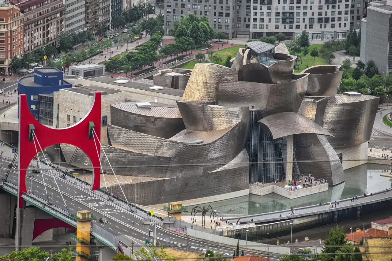 The Guggenheim Museum Bilbao beside the La Salve bridge and its red arch