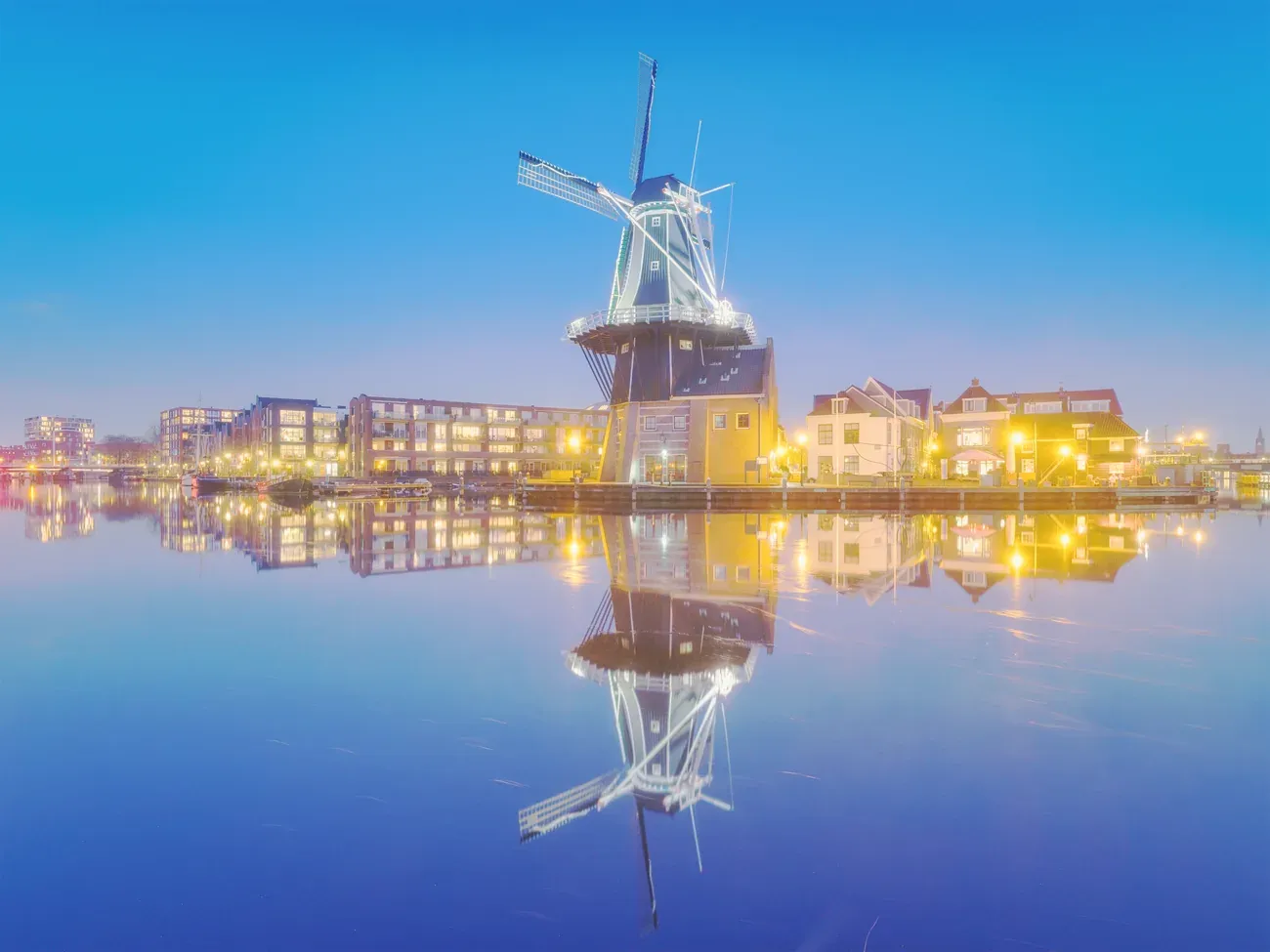 Windmill De Adriaan reflected in the water at blue hour, Haarlem, Netherlands