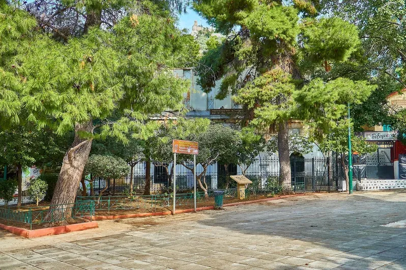 The surviving facade of Hadrian's Reservoir behind pine trees on Dexameni Square in Kolonaki, Athens