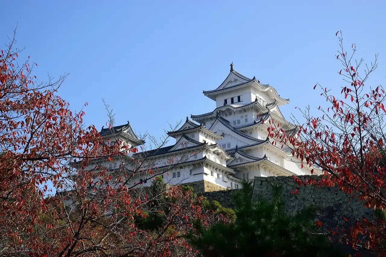 Himeji Castle framed by red autumn branches in Hyogo prefecture
