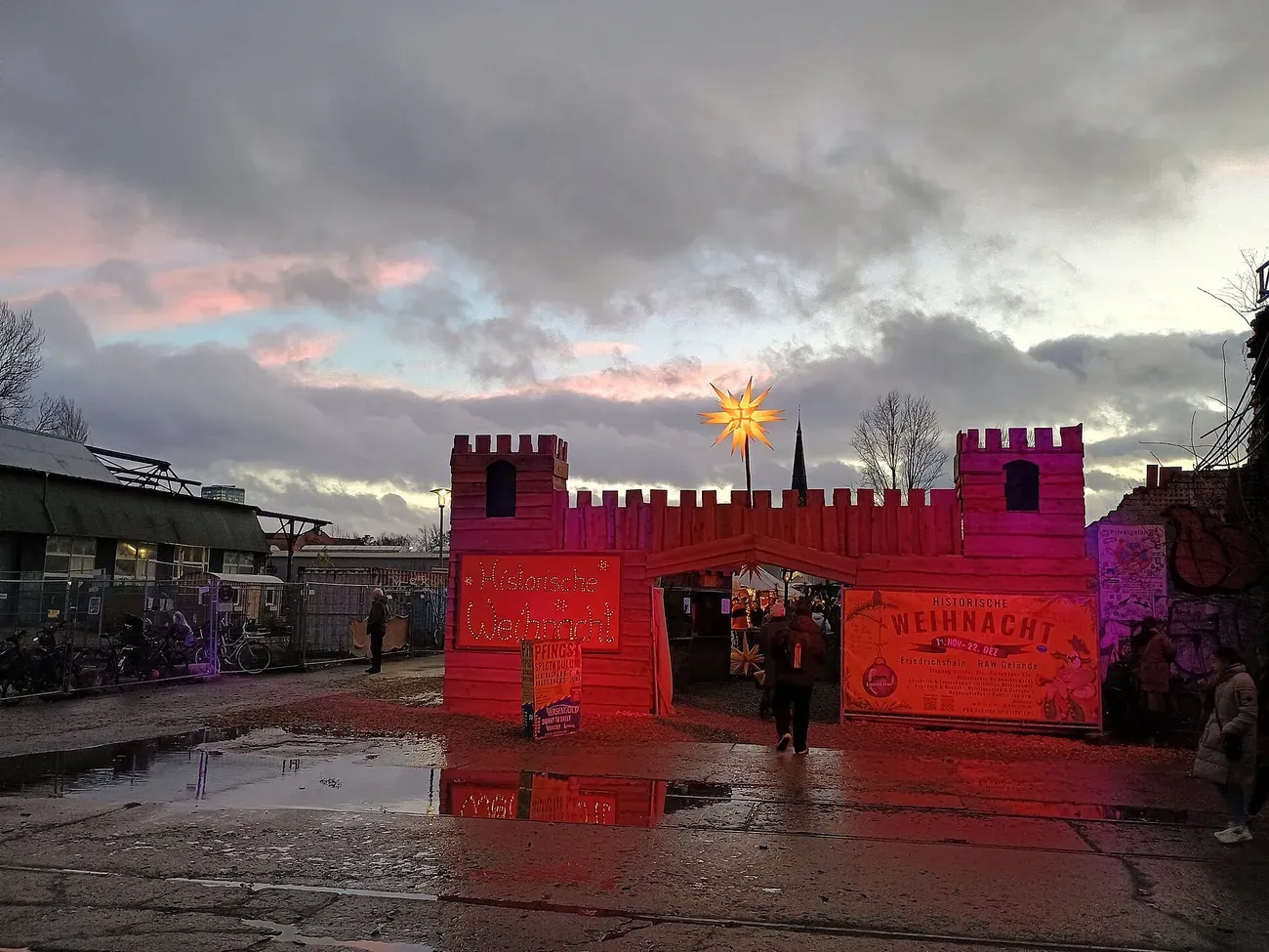 The red-lit castle gate of the Historischer Weihnachtsmarkt on the RAW grounds in Friedrichshain, Berlin