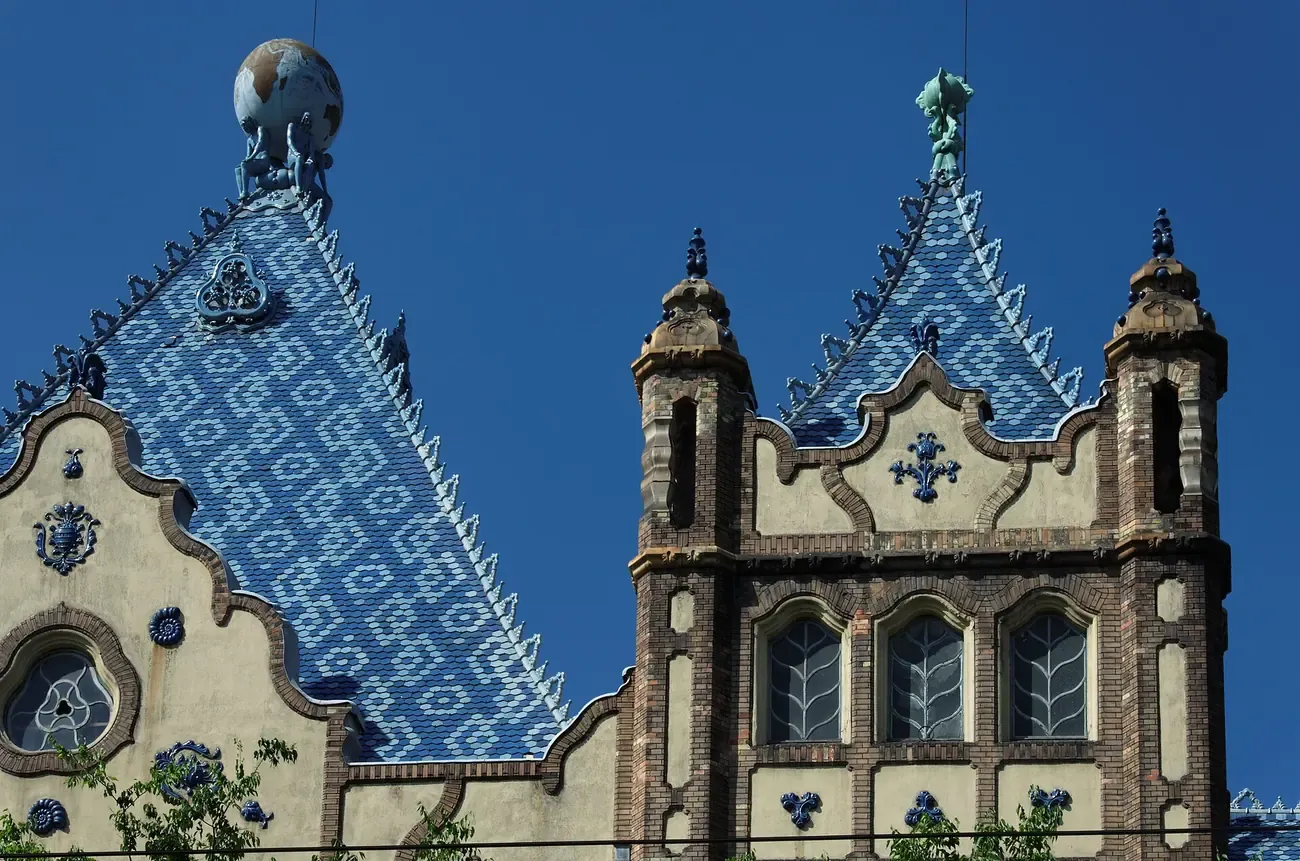 Blue Zsolnay-tiled roof of the Hungarian Geological Institute in Budapest, topped by figures carrying a globe