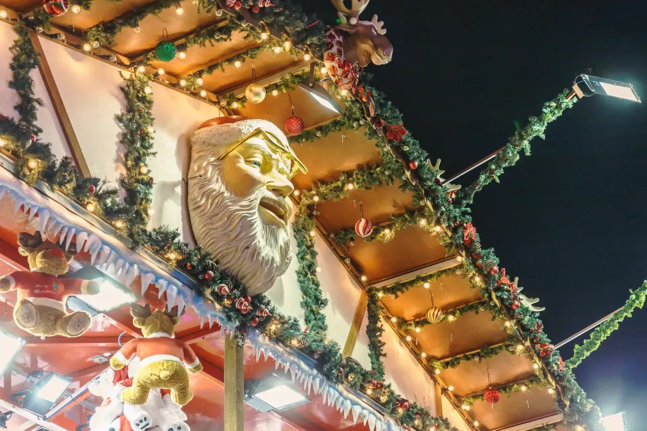 Carved Santa face and garlands on a stall roof at Hyde Park Winter Wonderland in London