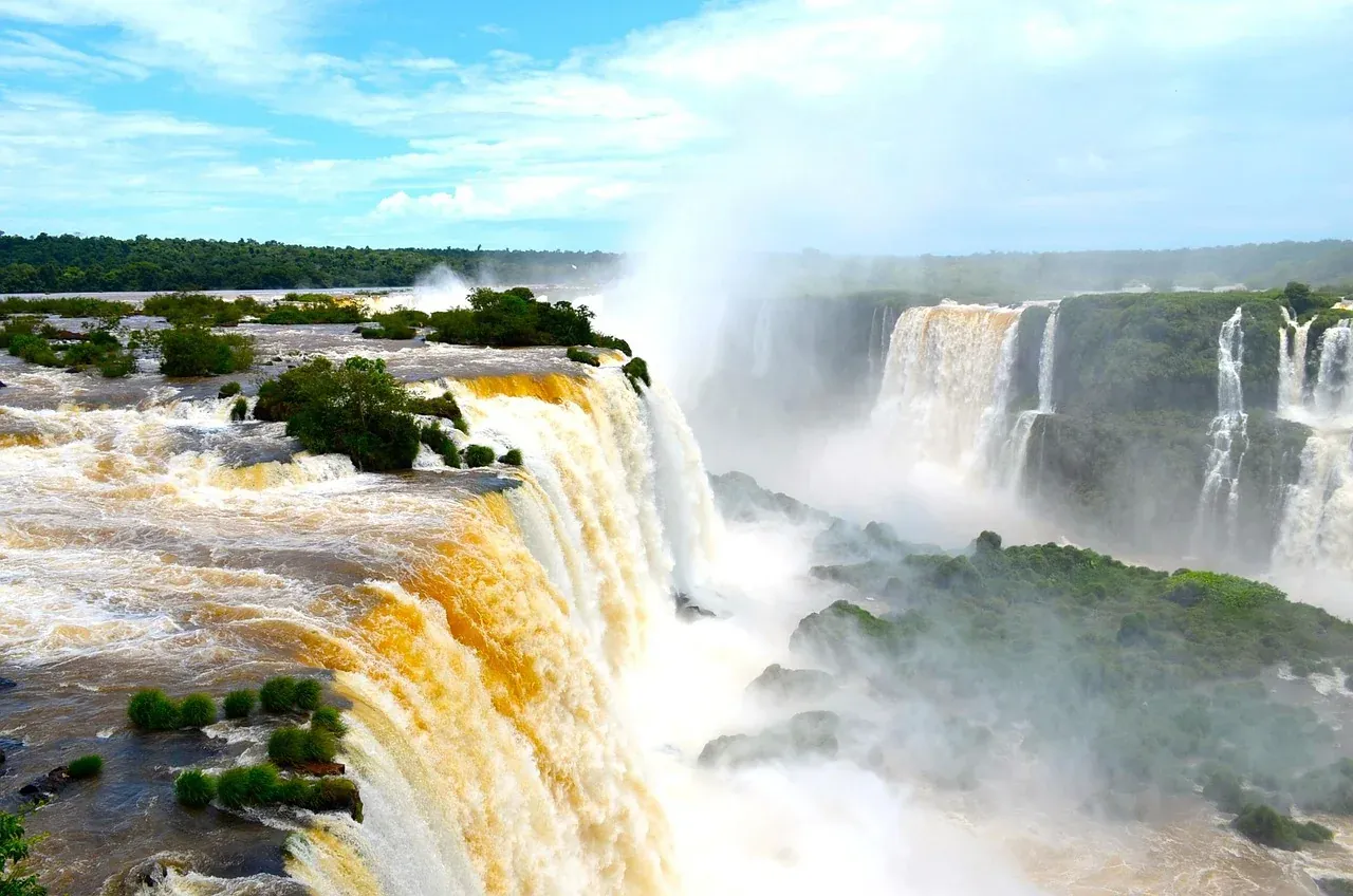 Water dropping over the Iguazu Falls with spray rising from the gorge