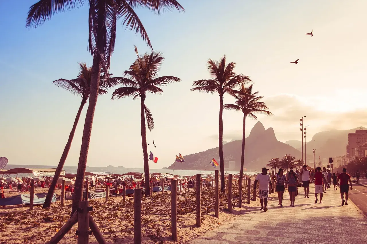 Palm trees along the Ipanema promenade with the Dois Irmaos peaks beyond