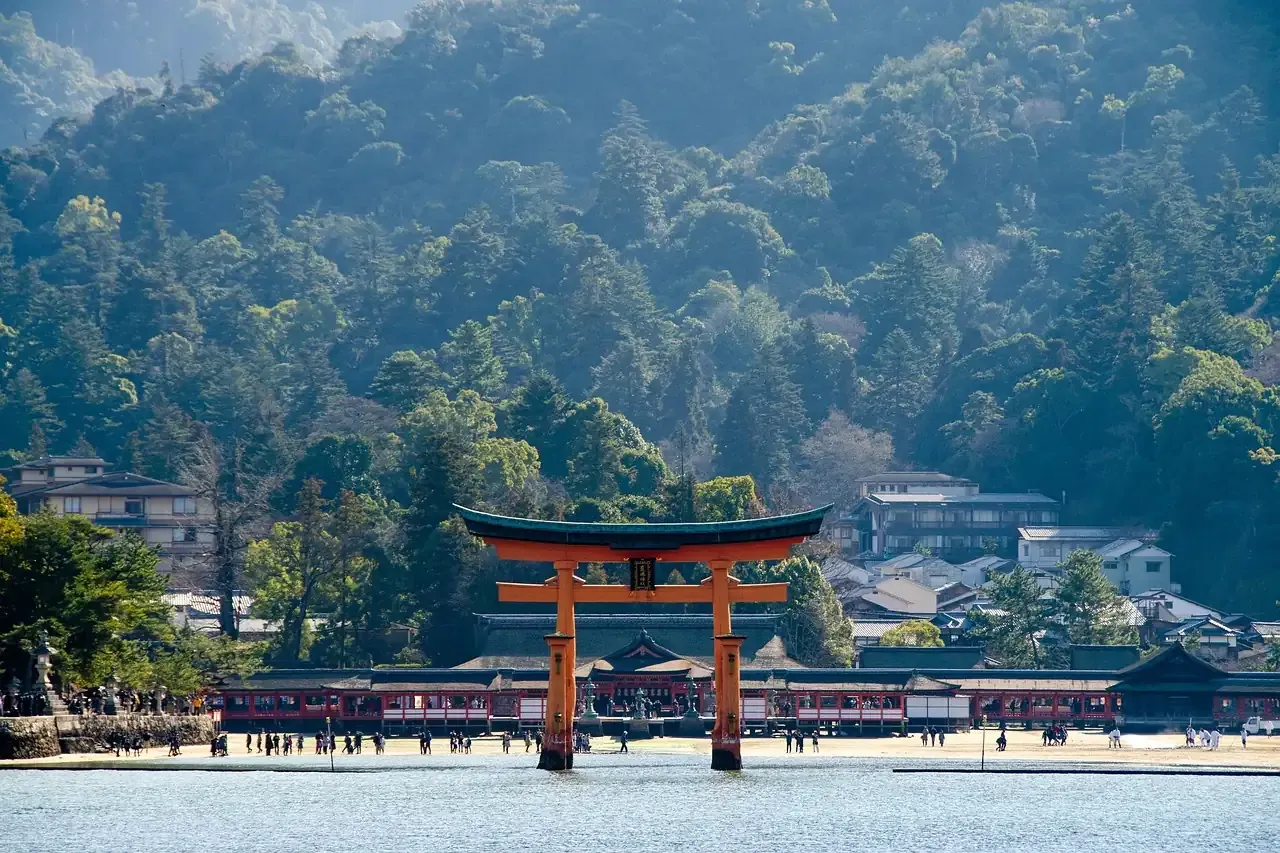 Itsukushima Shrine and its torii below the wooded hills of Miyajima