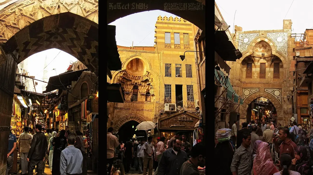 A crowded bazaar street and historic gate at Khan el-Khalili in Cairo