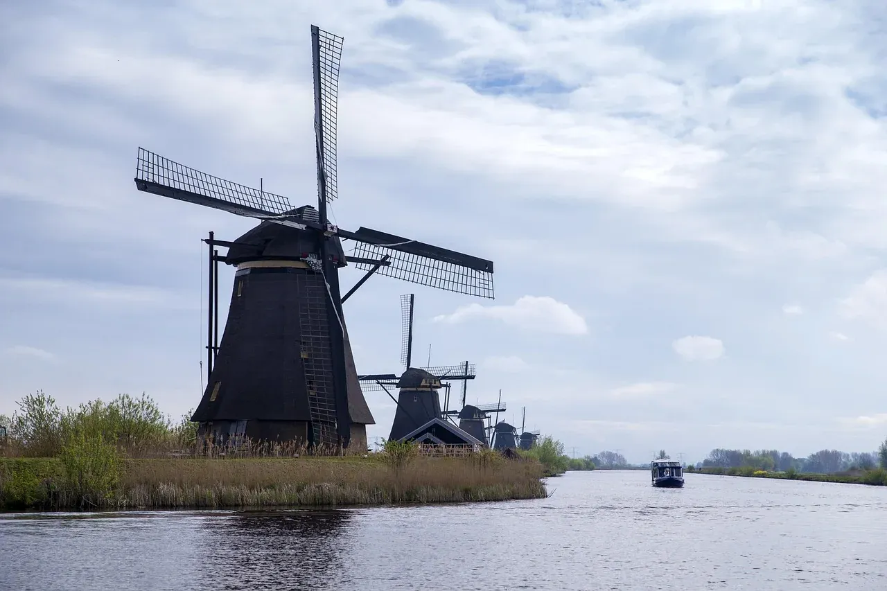 A drainage mill at Kinderdijk with a small boat passing along the polder canal