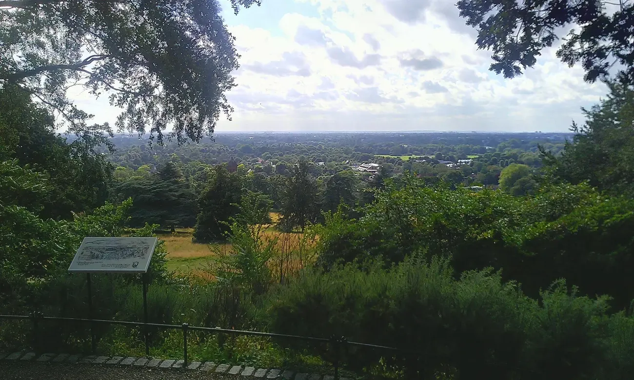 Trees framing the view west over the Thames Valley from King Henry's Mound in Richmond Park, London