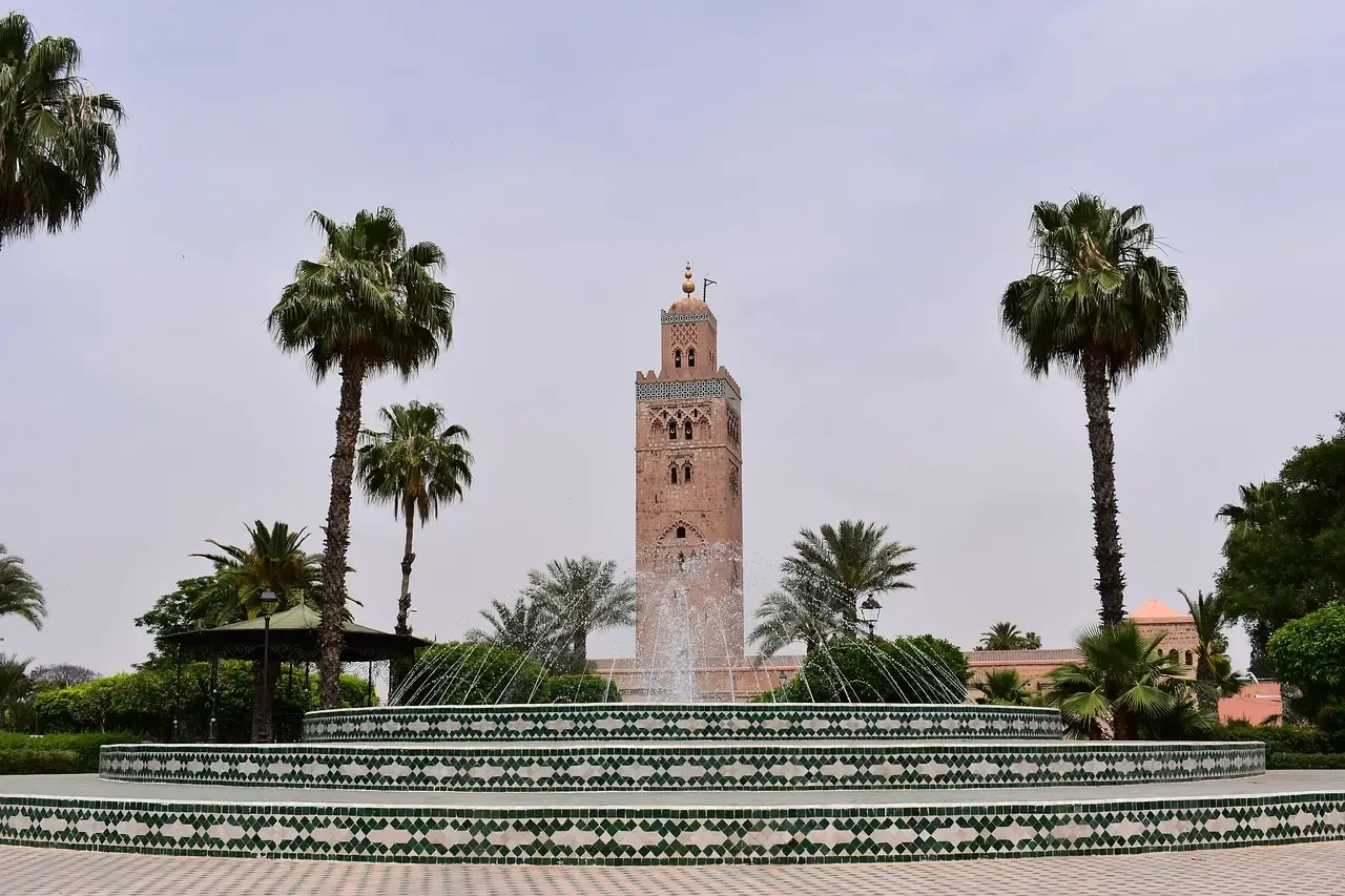 The Koutoubia minaret above a fountain and palm trees in Marrakech